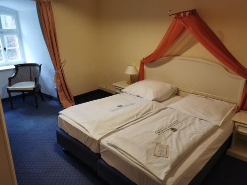 a hotel room with a bed with a red canopy at Hotel & Spa Wasserschloss Westerburg in Westerburg