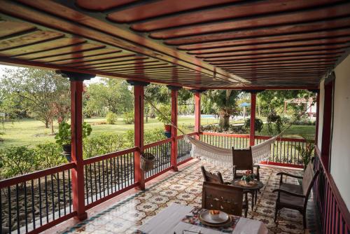 a screened in porch with a table and chairs at Finca Hotel in Armenia