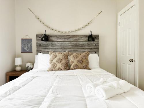 a bedroom with a white bed with towels on it at Spring Street Suites in Evansville