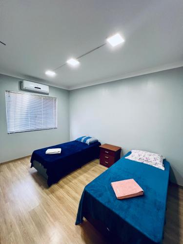 a room with two beds and a window in it at Moderno Sobrado Climatizado com Ar Quente e Frio in Cascavel