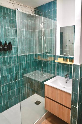 ein grün gefliestes Bad mit einem Waschbecken und einer Dusche in der Unterkunft Casa Del Mar, en plein centre ville! in Bandol