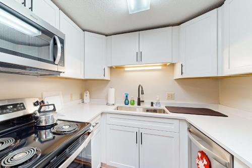 a kitchen with white cabinets and a stove top oven at Easy Street Retreat in Sugar Mountain