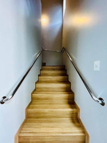 a stair case in a building with a wooden staircase at Moderno Sobrado Climatizado com Ar Quente e Frio in Cascavel
