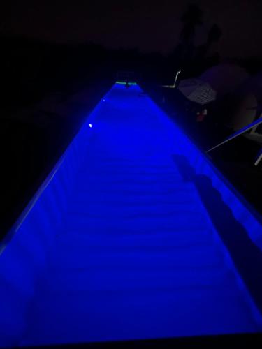 a blue lighted staircase in a dark room at Iglú Barba Roja con vista al cielo in Barra de Navidad