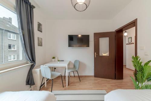 ein Esszimmer mit Tisch und Stühlen und einem Fenster in der Unterkunft Eco Retreat Spacestays - Smart TV - WIFI in Essen