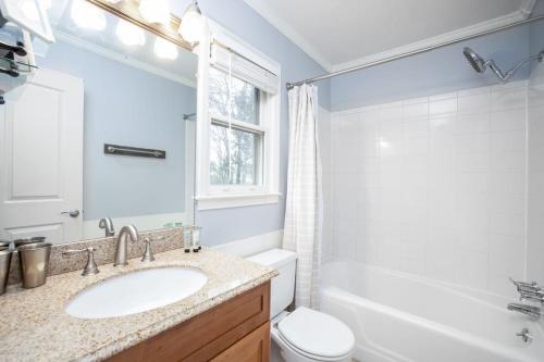ein Badezimmer mit Waschbecken, Toilette und Spiegel in der Unterkunft Beautiful wooded home in Popular SouthPark in Charlotte