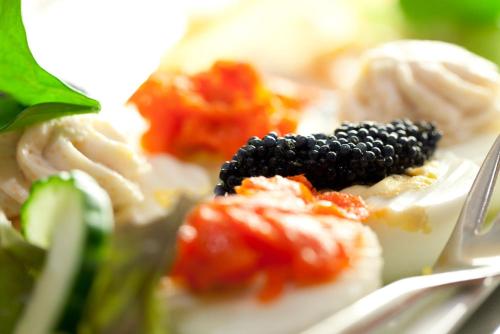 a plate of food with pasta and blackberries and a fork at Hotel Garden Cottage mit kostenfreien Parkplätzen in Dresden