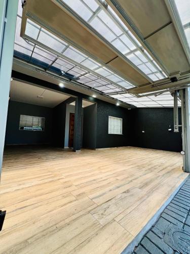 a large room with a wooden floor and a skylight at Moderno Sobrado Climatizado com Ar Quente e Frio in Cascavel