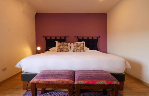 a bedroom with a large white bed with two pillows at Casa Muru By Wynwood House in Cusco