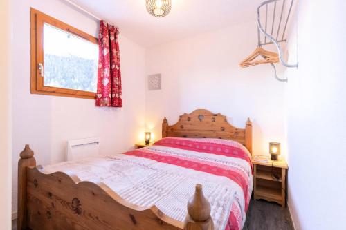 une chambre avec un lit en bois et une fenêtre dans l'établissement Les Chalets D'arrondaz - 3 pièces appartement 4/6 personnes MAE-2940, à Modane