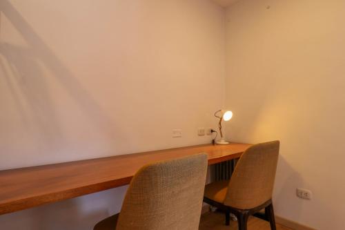 a desk with two chairs and a lamp on it at Casa Muru By Wynwood House in Cusco