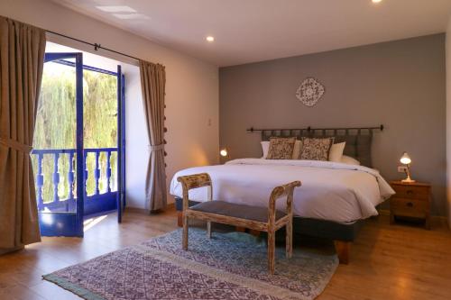 a bedroom with a bed and a chair and a window at Casa Muru By Wynwood House in Cusco