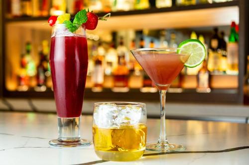 three cocktails sitting on a counter in a bar at Crowne Plaza Seattle Newly Renovated with No Resort Fee in Seattle