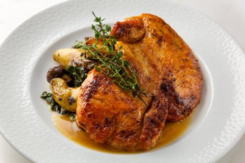 a plate of food with a chicken and vegetables at Crowne Plaza Seattle Newly Renovated with No Resort Fee in Seattle