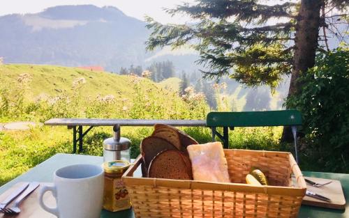 a basket of bread sitting on a table with a cup at Bründling-Alm Berggasthof auf 1167m auf dem Hochfelln in Bergen