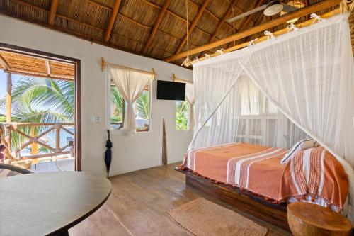 een slaapkamer met een bed, een tv en een tafel bij Panchos Paradise Cabaña Parota in Puerto Vallarta