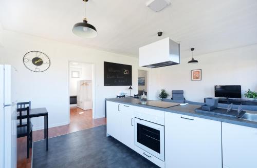 une cuisine avec des armoires blanches et un comptoir dans l'établissement Wie d'Heim - Gîte d'Alsace tout équipé, à Wintzenheim