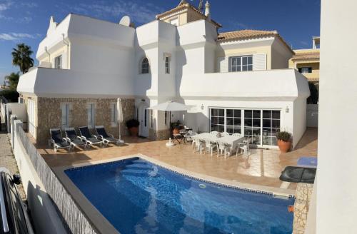 a villa with a swimming pool in front of a house at Casa Sarena in Altura