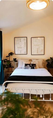 une chambre avec un lit avec deux tableaux au mur dans l'établissement La Green Room, à Poitiers