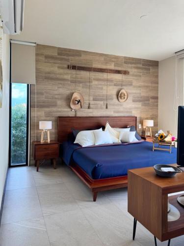 a bedroom with a blue bed and a wooden wall at BOHO Loft Steps from the Beach in Holbox Island