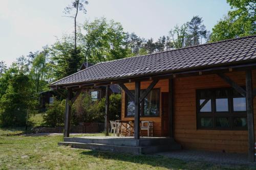 a log cabin with a porch and a table at Domki nad jeziorem Węgorzyno in Augustowo