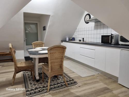 une cuisine avec une table et des chaises dans une cuisine dans l'établissement La bruyère, à Minihy-Tréguier