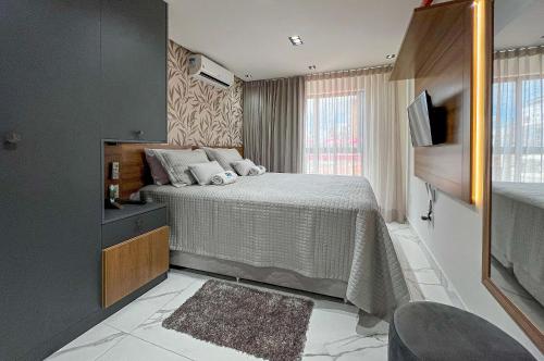 ein kleines Schlafzimmer mit einem Bett und einem Fernseher in der Unterkunft Charmoso Bessa 200m da Praia 2 Quartos 5 Pessoas in Nossa Senhora do Livramento