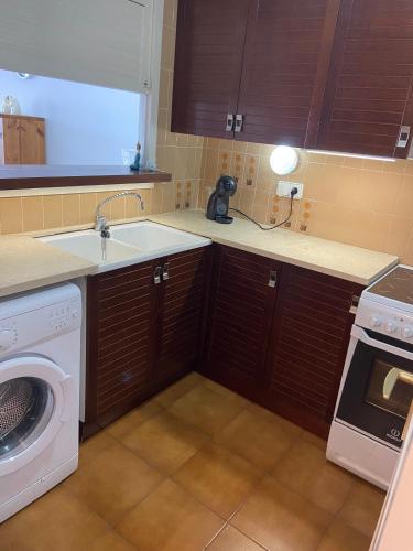 a kitchen with a sink and a washing machine at Ca La Ona in L'Escala