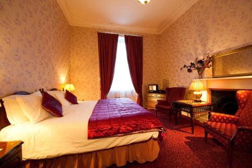 Habitación de hotel con cama y chimenea en The Ben Doran Guest House, en Edimburgo