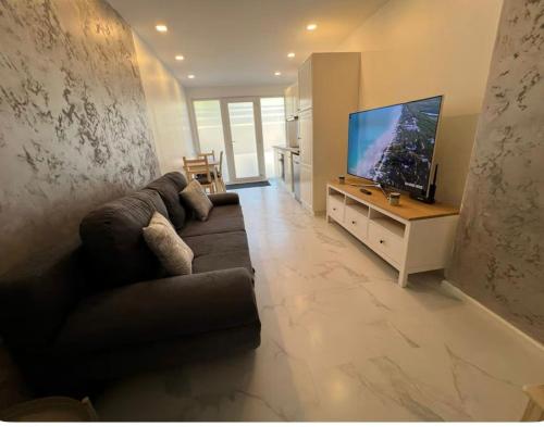 a living room with a couch and a flat screen tv at IL punto in Avranches