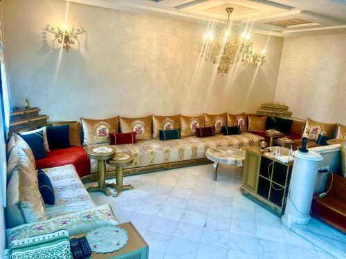 a living room with a couch and a chandelier at Prestigia luxury appartement in Fès