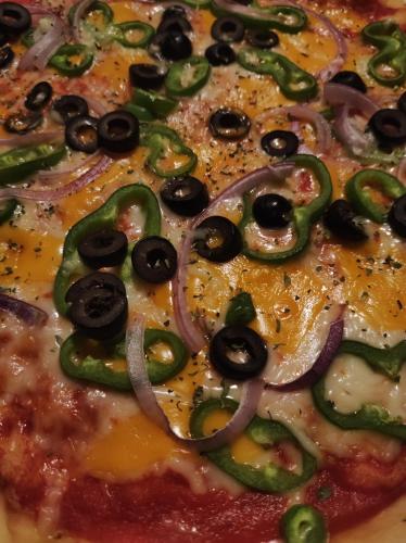 a pizza with black olives and onions on it at Habitaciones con encanto en Ilurdoz in Zuriáin