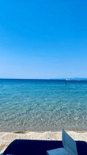 a book laying on the beach near the water at khouse - Personal Paradise in Neos Marmaras
