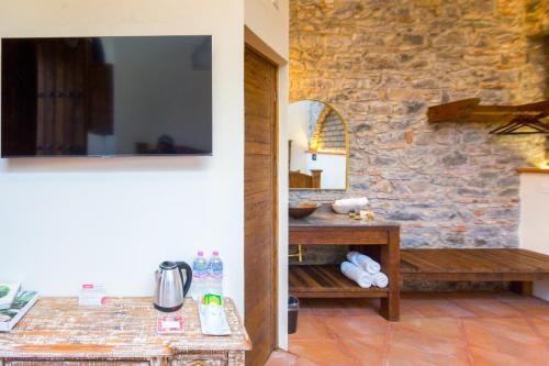 a living room with a stone wall and a television at Mágica Suit en Centro Histórico in Puebla