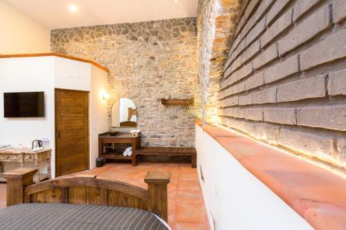 a room with a stone wall and a bench at Mágica Suit en Centro Histórico in Puebla