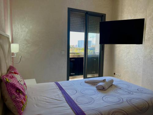 a bedroom with a bed with a large window at Prestigia luxury appartement in Fès