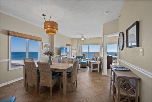 a dining room with a table and chairs and the ocean at Tidewater Unit 801 in Orange Beach