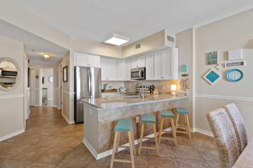 a kitchen with a counter and stools in a room at Tidewater Unit 801 in Orange Beach
