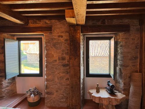 a room with two windows and a table in it at Casita Meu Pai in Boimorto