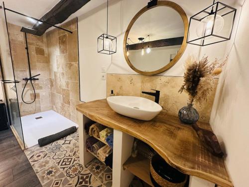 une salle de bain avec un lavabo et un miroir dans l'établissement Ferme Le Bacou, à Caraman