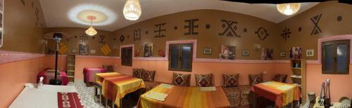 a restaurant with tables and signs on the wall at Riad Dades Birds in Boumalne