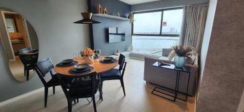 a dining room with a table and chairs and a window at Parque do Cais - Flats Premium no Recife por Yolo in Recife