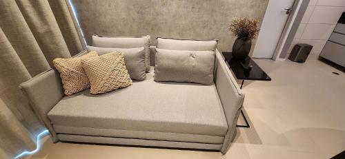 a couch with pillows on it in a room at Parque do Cais - Flats Premium no Recife por Yolo in Recife