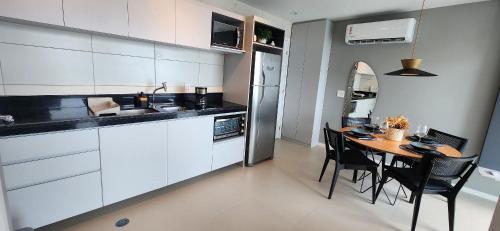 a kitchen with a table and some chairs in a room at Parque do Cais - Flats Premium no Recife por Yolo in Recife