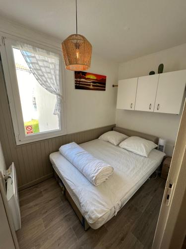 un letto in una stanza con una finestra di Appartement a 70m de la plage et l estacade de Capbreton a Capbreton