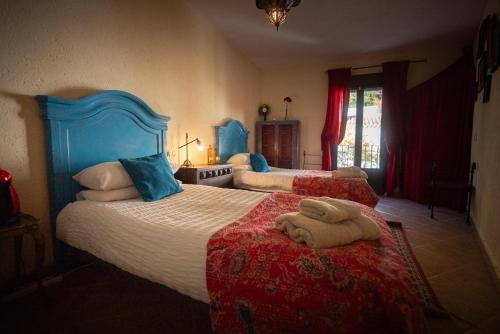 a bedroom with two beds with red and blue at Eagles Nest - Massive townhouse with Pool with outstanding views in Algodonales
