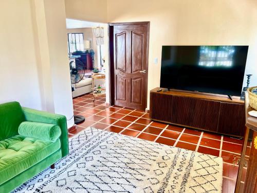 a living room with a green couch and a flat screen tv at Hotel Villa Toti in Santa Veronica