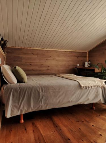 a bedroom with a bed with a wooden wall at Habitaciones con encanto en Ilurdoz in Zuriáin