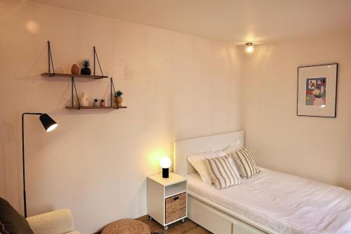 - une petite chambre avec un lit et une lampe dans l'établissement Clair Val, au Havre