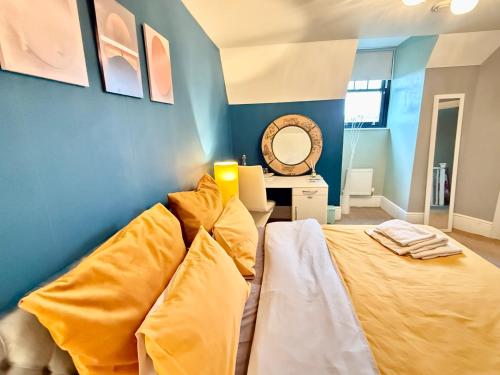 a blue room with a bed and a mirror at Upton Country Park Guest House in Northampton